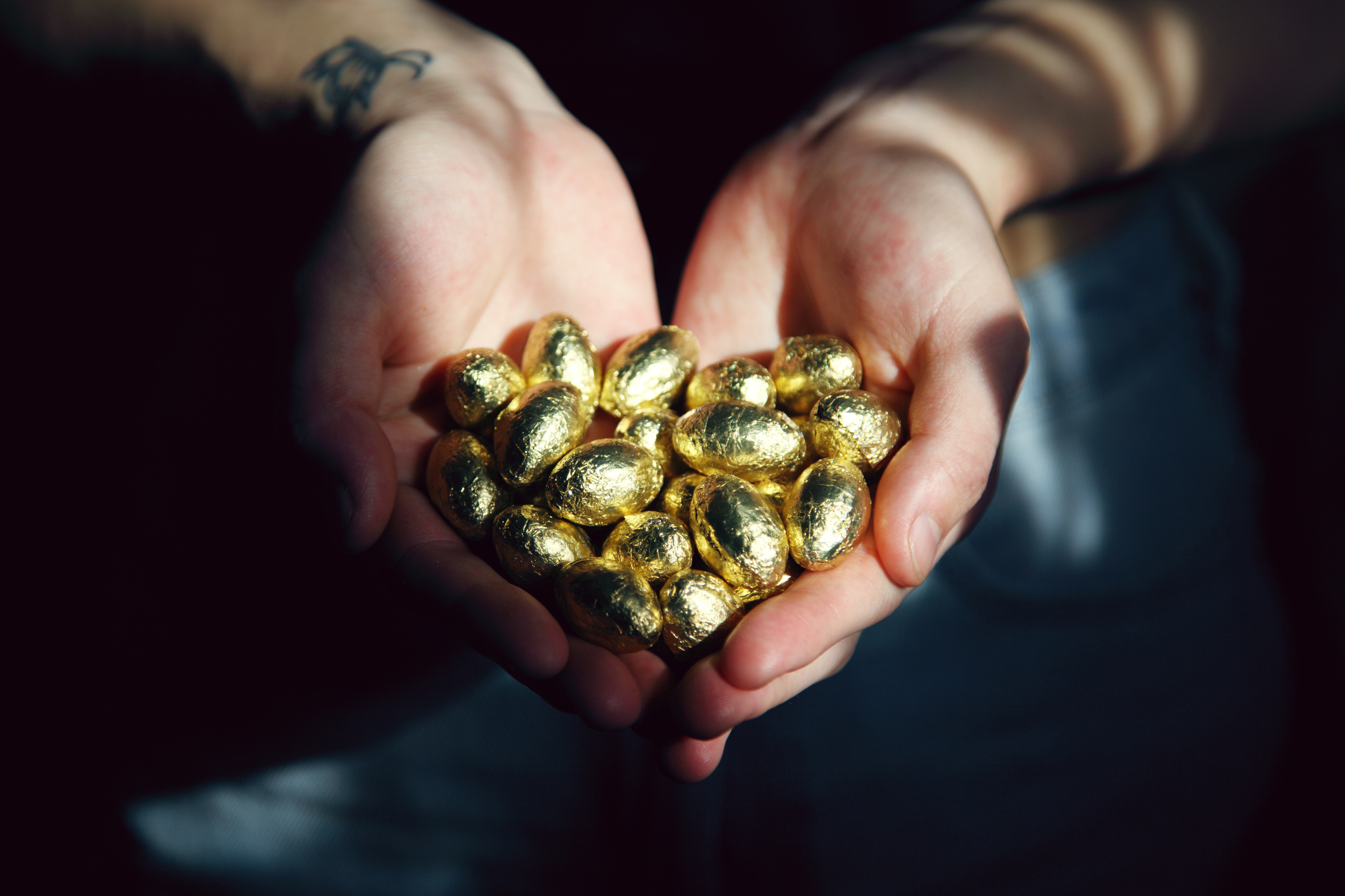 A pair of hands hold a small mound of tiny golden eggs